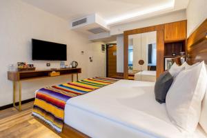 a bedroom with a large white bed and a television at Hay Hotel Alsancak in Izmir