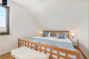 a bedroom with a large wooden bed with blue pillows at Ferienhaus Sonnendeck in Ueckeritz