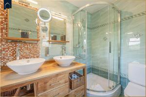 a bathroom with two sinks and a glass shower at Ferienhaus Sonnendeck in Ueckeritz +32 photos