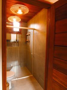 a bathroom with a toilet and a glass shower at Casa Namolmar in Acaraú