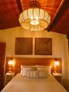 a bedroom with a large bed and a chandelier at Casa Namolmar in Acaraú +18 photos