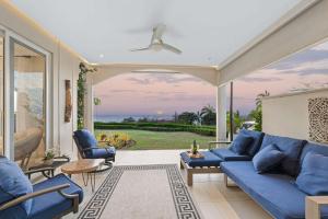 a living room with a blue couch and chairs at Infinity Pools & Sunsets Over Tamarindo Bay in Tamarindo
