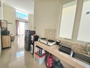 a kitchen with a counter with a stove and a sink at Villa Kayana AA9 in Batu +3 photos