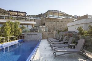 a row of chairs sitting next to a swimming pool at Spektr Boutique Hotel Yalikavak in Yalıkavak