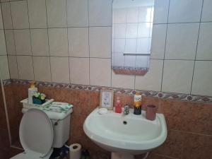 a bathroom with a sink and a toilet and a mirror at Studio Apartment, Nyali Mombasa in Mombasa