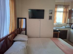 a bedroom with two beds and a flat screen tv at Studio Apartment, Nyali Mombasa in Mombasa +2 photos