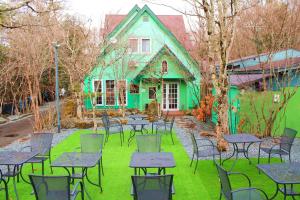 a group of tables and chairs in front of a green house at Irodorinoyado Kaede Izumi - Vacation STAY 70082v in Yamanakako