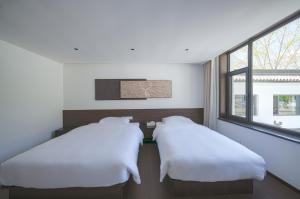 Postel nebo postele na pokoji v ubytování In the Clouds - Courtyard Twin Room