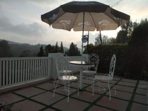 a table and chairs and an umbrella on a patio at FN's Eternia in Ooty
