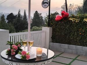 a table with two glasses of champagne and flowers at FN's Eternia in Ooty