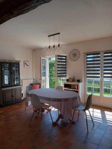 a kitchen and dining room with a table and chairs at La p'tite Maison de Mimi in Fontaine-le-Dun +14 photos
