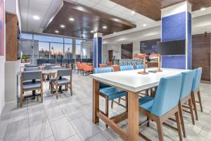 a dining room with tables and blue chairs at Holiday Inn Express & Suites Moore by IHG in Moore
