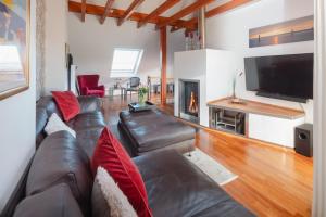 a living room with a leather couch and a fireplace at Ferienloft Inselliebe in Norderney