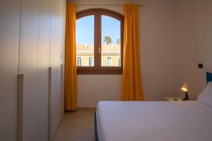 een slaapkamer met een bed en een groot raam bij Sph24 Appartamento Alghero Via Mazzini in Alghero