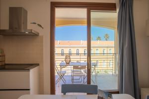 een keuken met uitzicht op een balkon met een tafel bij Sph24 Appartamento Alghero Via Mazzini in Alghero