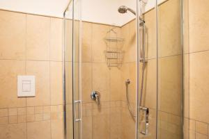 een douche met een glazen deur en een douchespoel bij Sph24 Appartamento Alghero Via Mazzini in Alghero +21 foto's