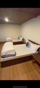 two twin beds in a room with at Hill Garden Homestay in Uttarey