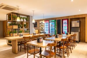 a restaurant with wooden tables and chairs at Uniclass Hotel Lapa in São Paulo