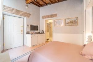 a bedroom with a bed and a tv and a door at Secret Studio Retreat in the Heart of the Ghetto by Houseeds in Rome