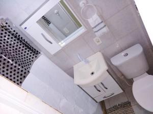 a white bathroom with a toilet and a sink at Teresopolis Apartamento Proximo a Feirinha in Teresópolis