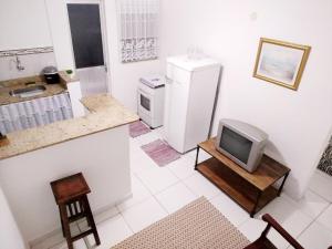 a kitchen with a refrigerator and a tv on a table at Teresopolis Apartamento Proximo a Feirinha in Teresópolis