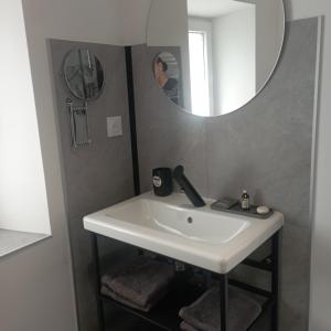 a bathroom with a white sink and a mirror at Cottage de charme en pierres à 25 mn de la côte de Granit rose in Bégard +25 photos