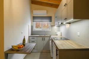 a kitchen with a sink and a bowl of fruit on a table at LazyDays in Analipsi in Análipsis