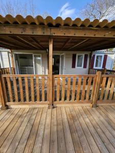 a wooden deck with awning on a house at Camping familial les Chalets d'Uza in Uza +9 photos