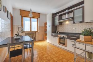 eine Küche mit Tisch und Stühlen in einem Zimmer in der Unterkunft Da Tiffany - soggiorna in centro a Gorizia con garage box e ascensore in Gorizia