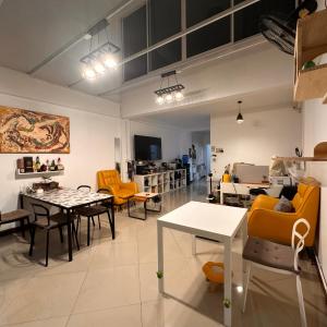 a living room with tables and chairs in a room at 소다호스텔 Soda HosteL in Chiang Mai +20 photos