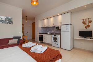 a kitchen and living room with a bed and a washing machine at Alto do Quintao Apartments in Portimão