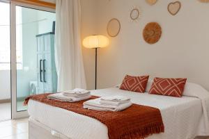 a bedroom with a bed with towels on it at Alto do Quintao Apartments in Portimão