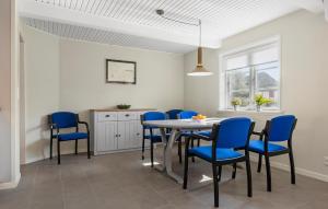 Hadsundにある3 Bedroom Amazing Home In Hadsundのダイニングルーム(テーブル、青い椅子付)