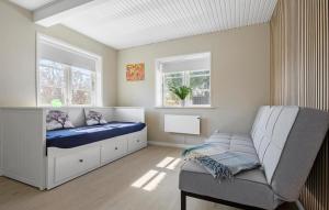 Hadsundにある3 Bedroom Amazing Home In Hadsundのベッドとソファと2つの窓がある寝室