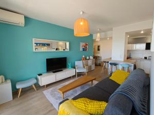 a living room with a couch and a dining room at Appartement toit terrasse Nice-ouest avec parking, clim et piscine in Nice