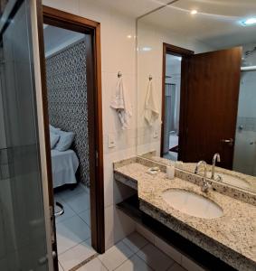 a bathroom with a sink and a mirror at Santorini na rua do hospital Premium Mater Dei Piscina Academia Jacuzzi Parque Areiao e Goiania Shopping tudo perto in Goiânia