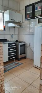 una cocina con estufa y refrigerador en hospedagem, en Lençóis