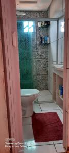 Un baño con inodoro y ducha de cristal. en hospedagem, en Lençóis