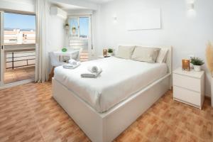 Un dormitorio blanco con una cama grande y un balcón. en Plazamar 039, en Torre del Mar