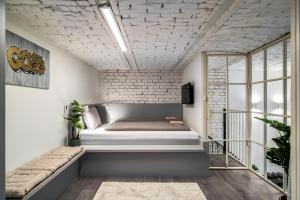a bed in a room with a brick wall at Paulay at Opera Suites P39 in Budapest