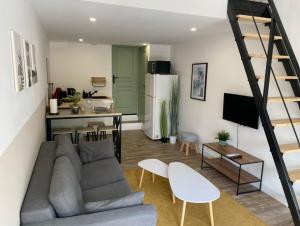 a living room with a couch and a kitchen at Eden Villeneuve - Suite & appartement in Villeneuve-lès-Maguelonne
