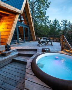 a hot tub on a deck next to a cabin at ALPINEST - Les Cabanes du Pas de la Louve in Serres