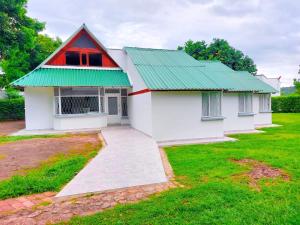 メルガルにあるCasa piscina privada Melgarの緑の屋根の小さな白い家