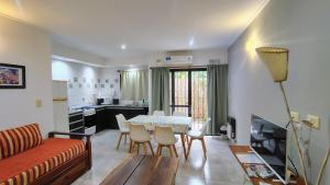 a living room with a table and chairs and a kitchen at Punto Márquez in Chascomús