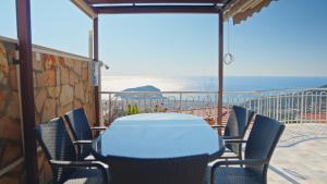a table and chairs on a balcony with a view of the beach at Qoople Villa Tepe with infinity pool and panoramic view in Alanya