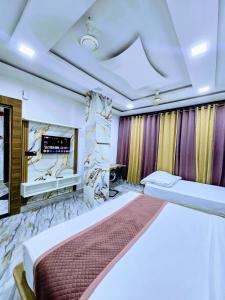 马图拉Premium Hotel Aarav Grand - Mathura Central - 5 Min distance from Railway Station的带一张大床和一个壁炉的卧室