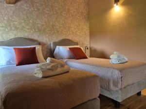 zwei Betten in einem Hotelzimmer mit Handtüchern darauf in der Unterkunft Il Bivio in Correggi