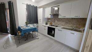 a small kitchen with a table and a sink at Il Rumore del Mare Beach House in Trinità dʼAgultu