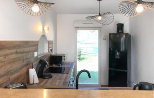 a kitchen with a black refrigerator and a sink at La Bastide in Grignan