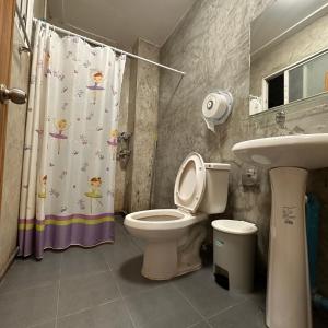 ein Badezimmer mit Toilette, Waschbecken und Duschvorhang in der Unterkunft 소다호스텔 Soda Hostel in Chiang Mai + 20 Fotos